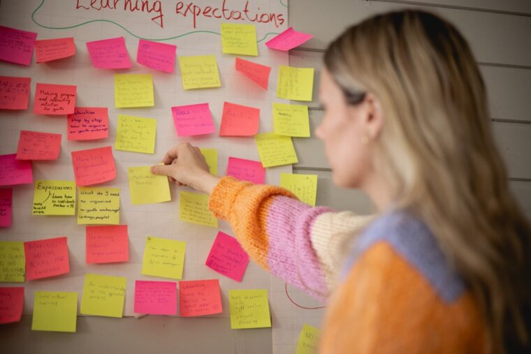 Kvinne ser på en vegg med postit-lapper