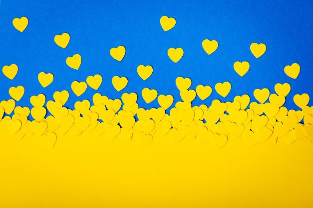 Gule hjerter i papir på blå bakgrunn. Symboliserer det ukrainske flagget.
