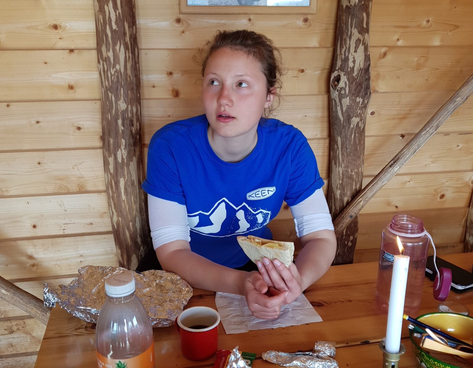 Bilde av ei dame som spiser norsk matpakke i en hytte.