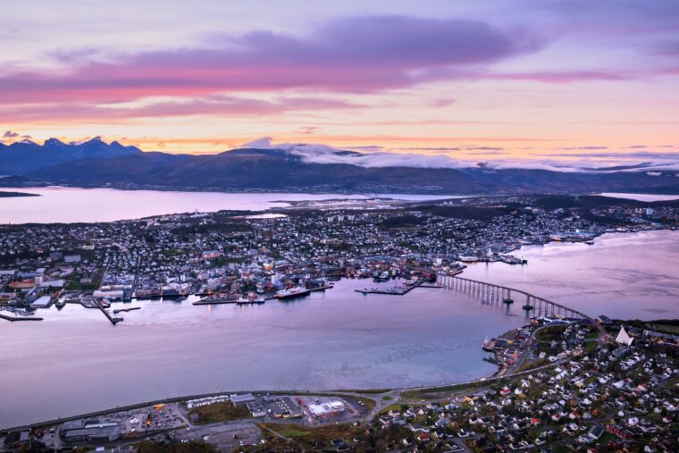 Utsiktsbilde over Tromsø med solnedgangen bak fjellene