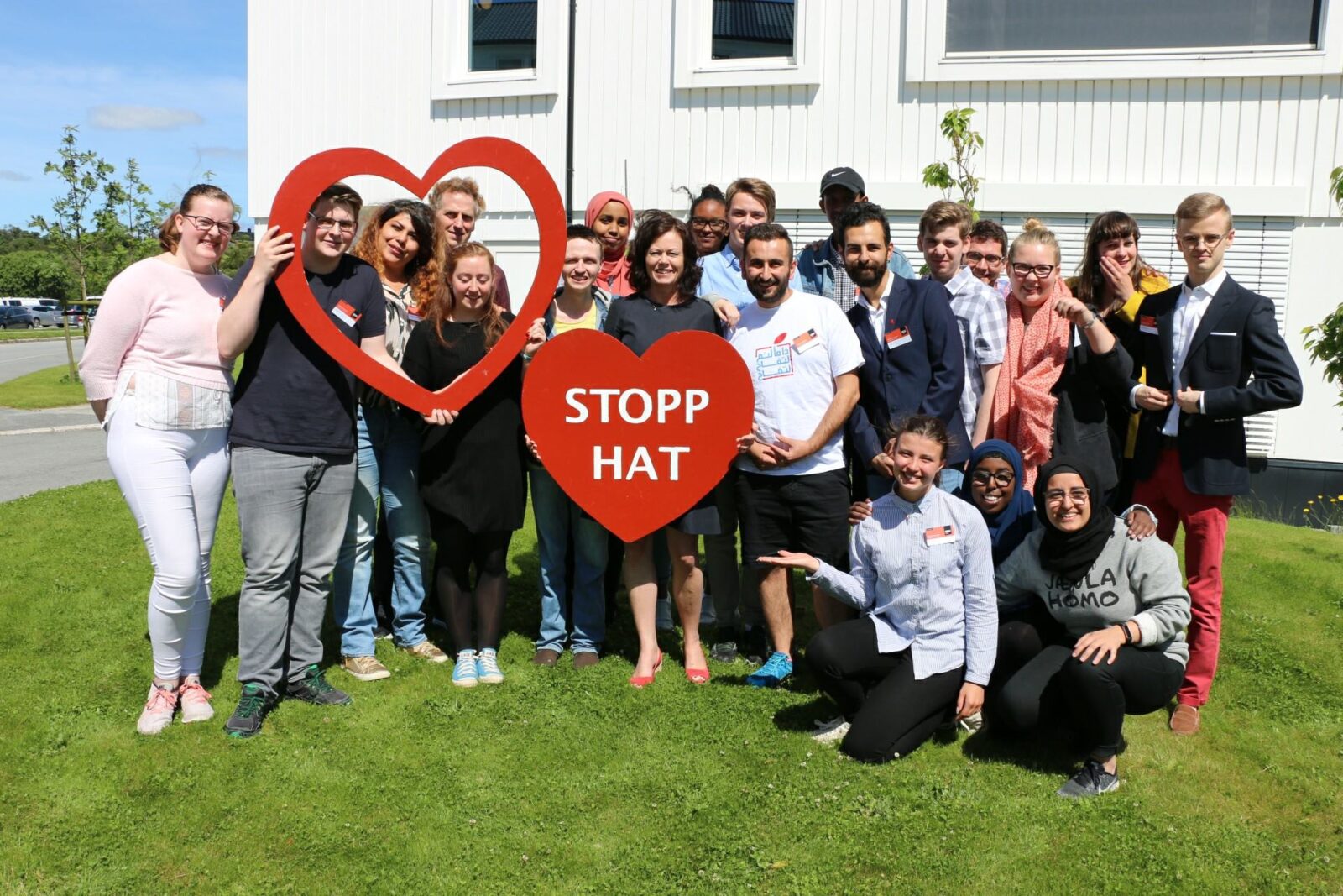 Gruppebilde av ungdommer og en statsråd som holdet et stort hjerte hvor det står 