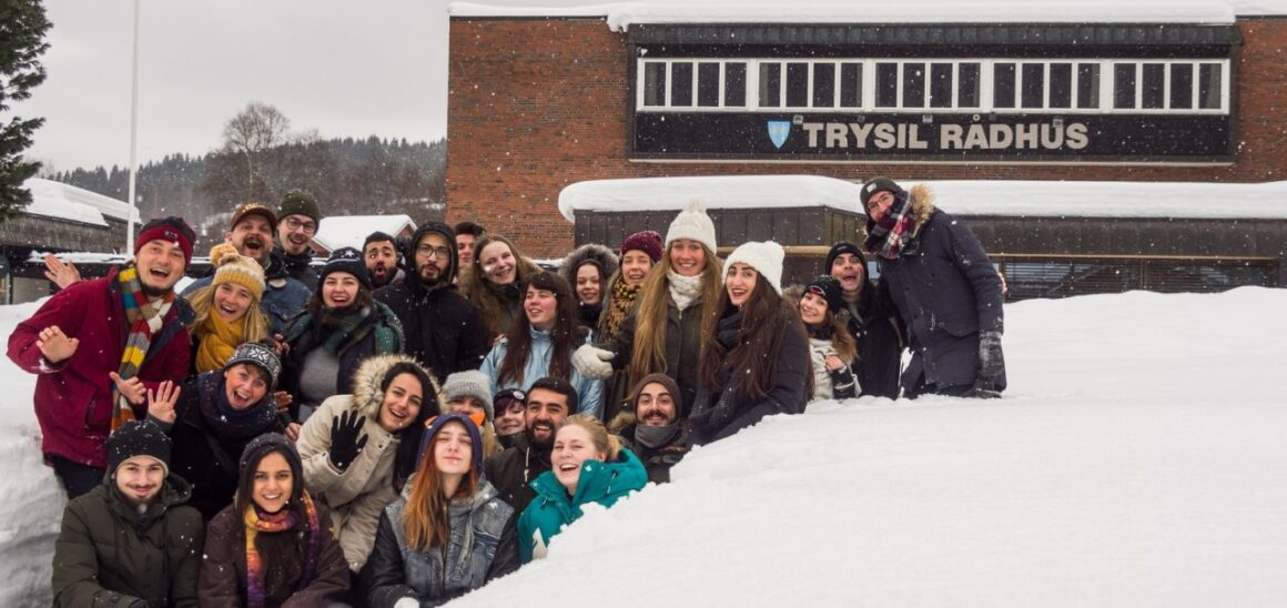 En gruppe med europeiske ungdommer poserer foran rådhuset i Trysil om vinteren