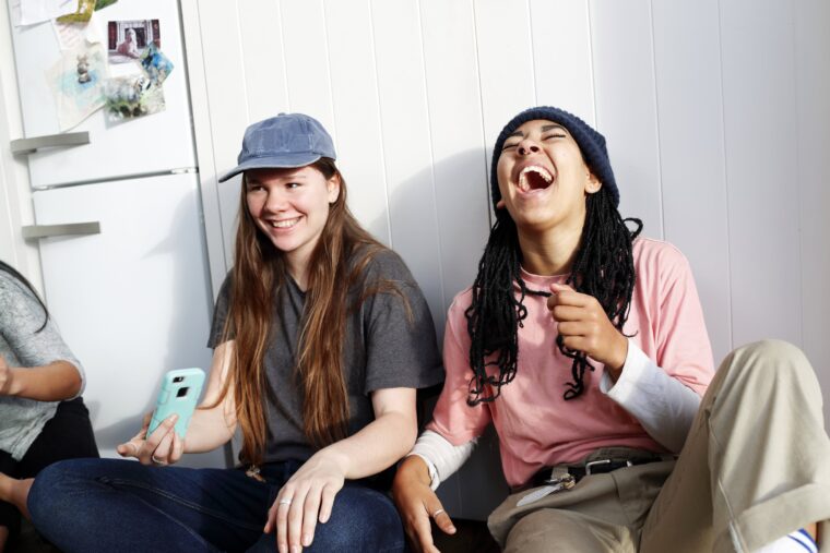 To unge kvinner med caps og lue ler