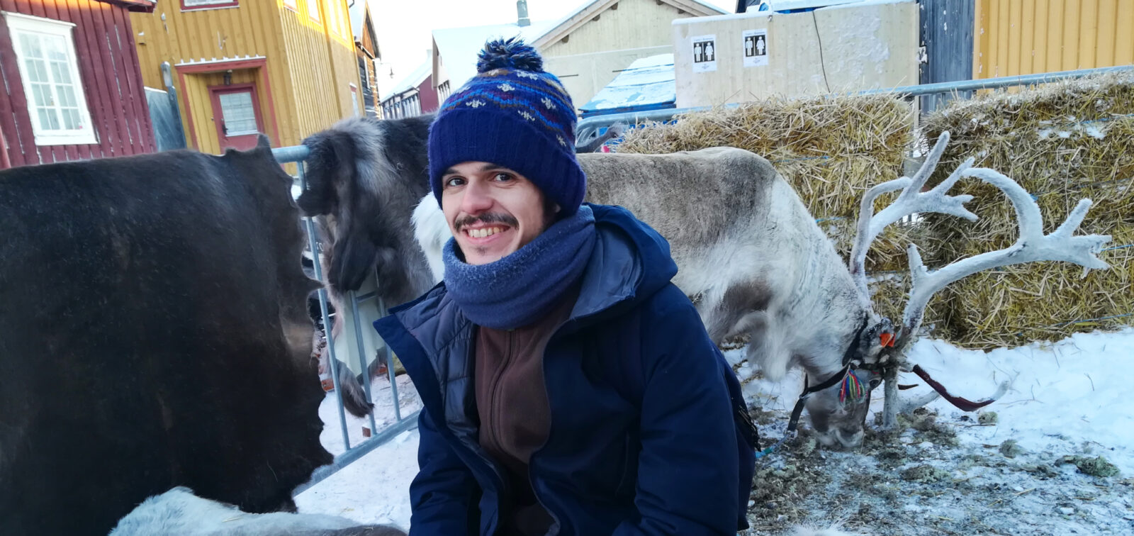 En ung frivillig fra Italia med et reinsdyr i bakgrunnen
