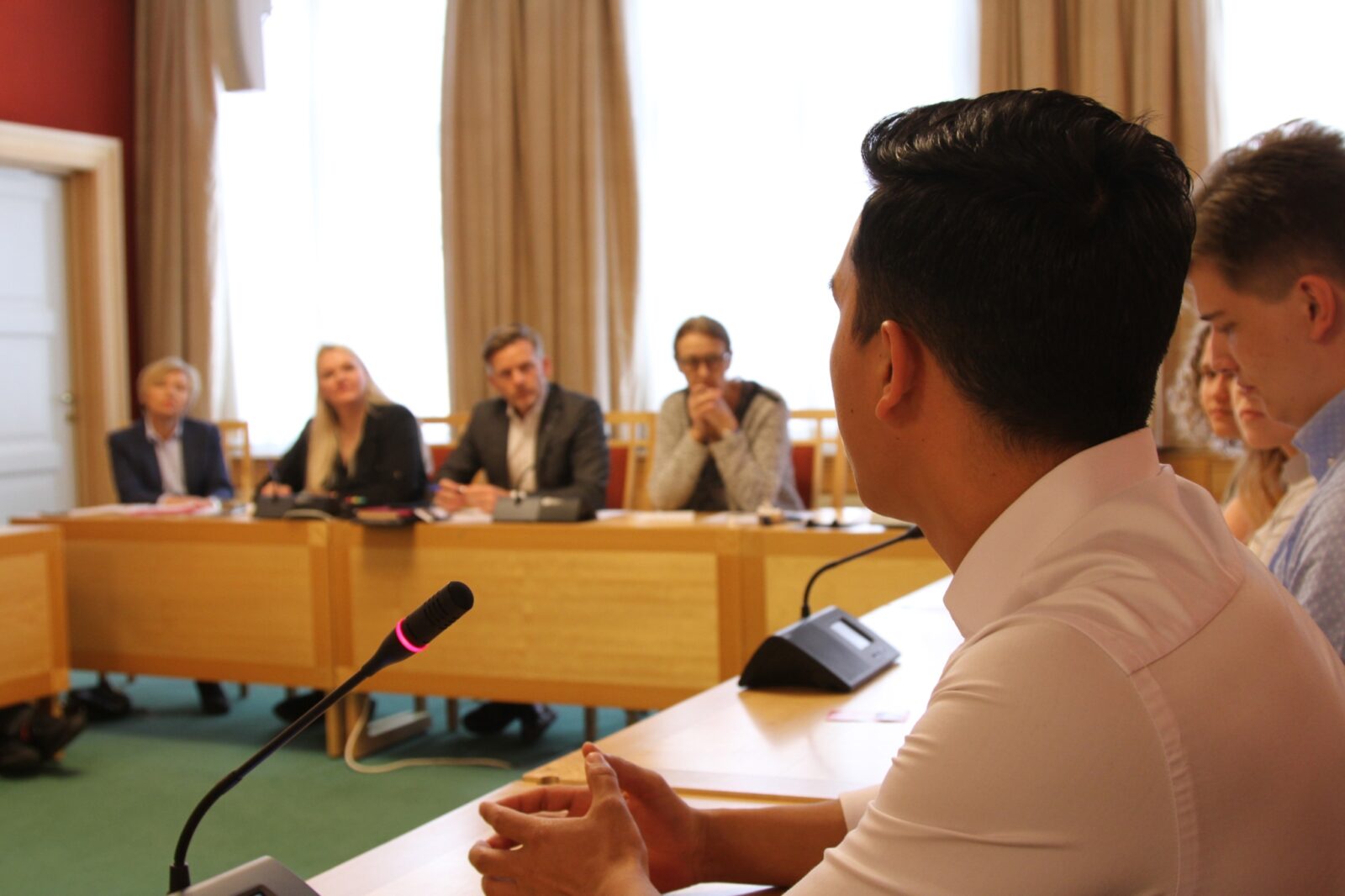 En ungdom taler i Stortinget foran stortingsrepresentanter