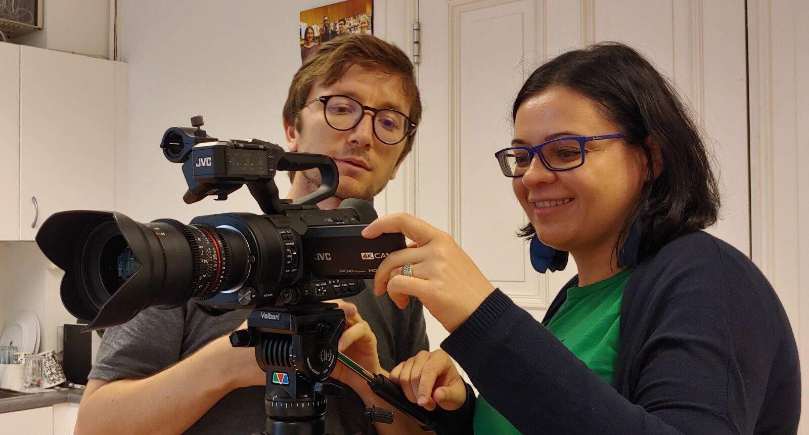 En mann og en kvinne står bak et videokamera som står på et stativ