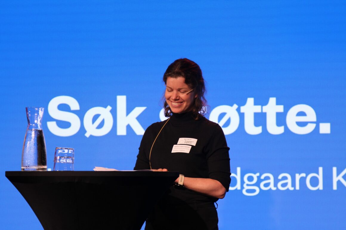 En kvinnelig ansatt i Erasmus+ holder en presentasjon fra scenen