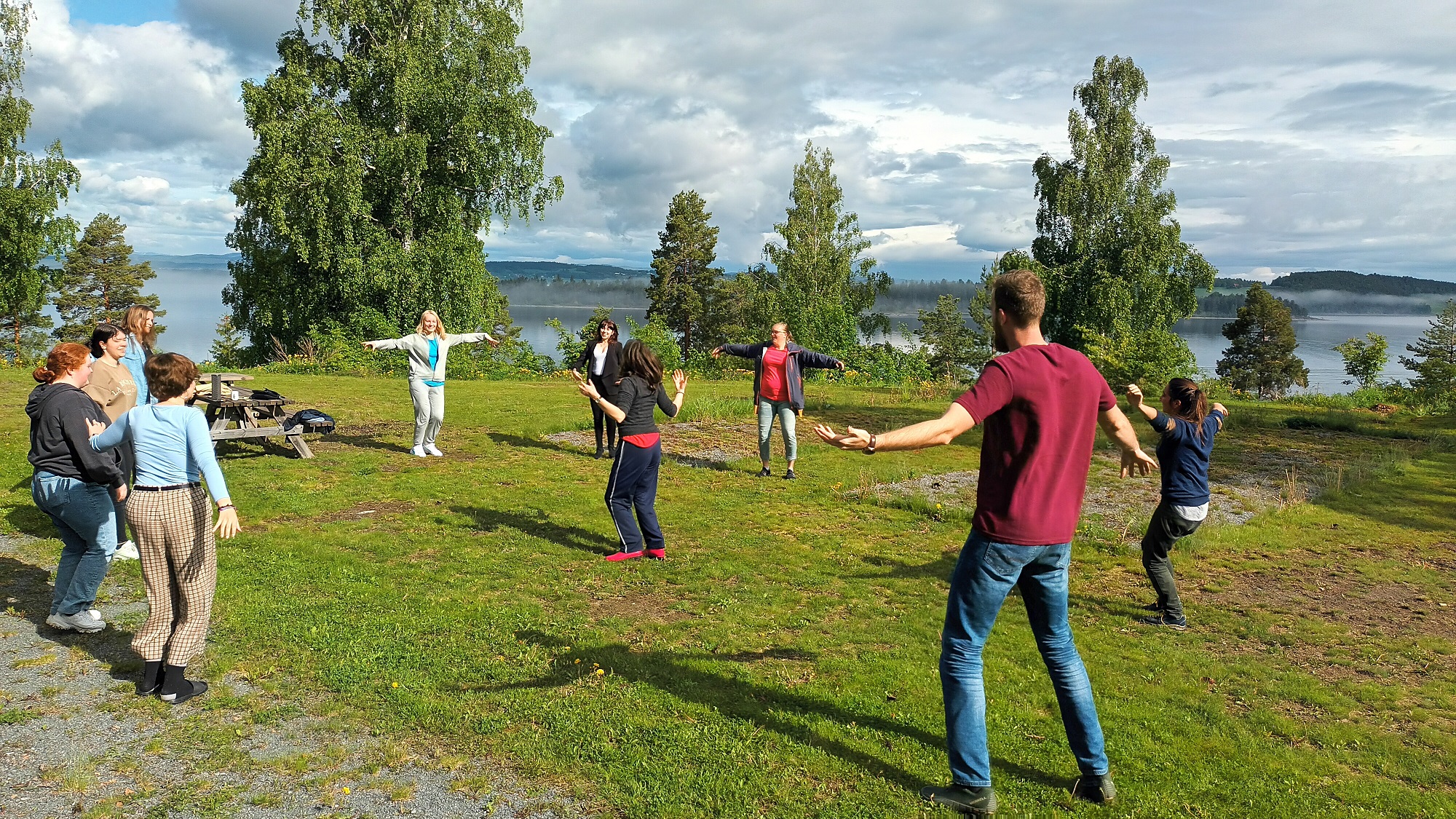 Mennesker står på en grønn gressplen med armene ut