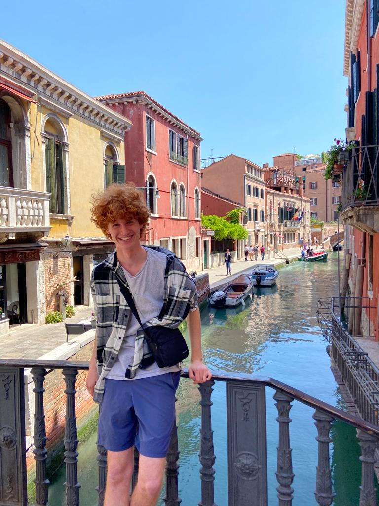 Bilde av en ung gutt som står på en bro i Venezia.